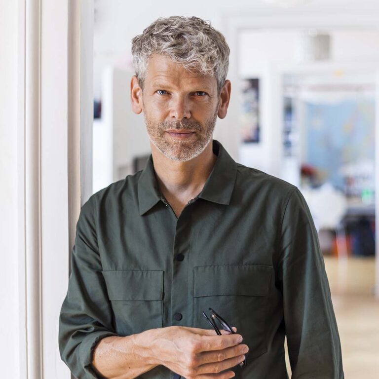 Portrait professionnel d’un homme dans la quarantaine, en contexte de bureau.